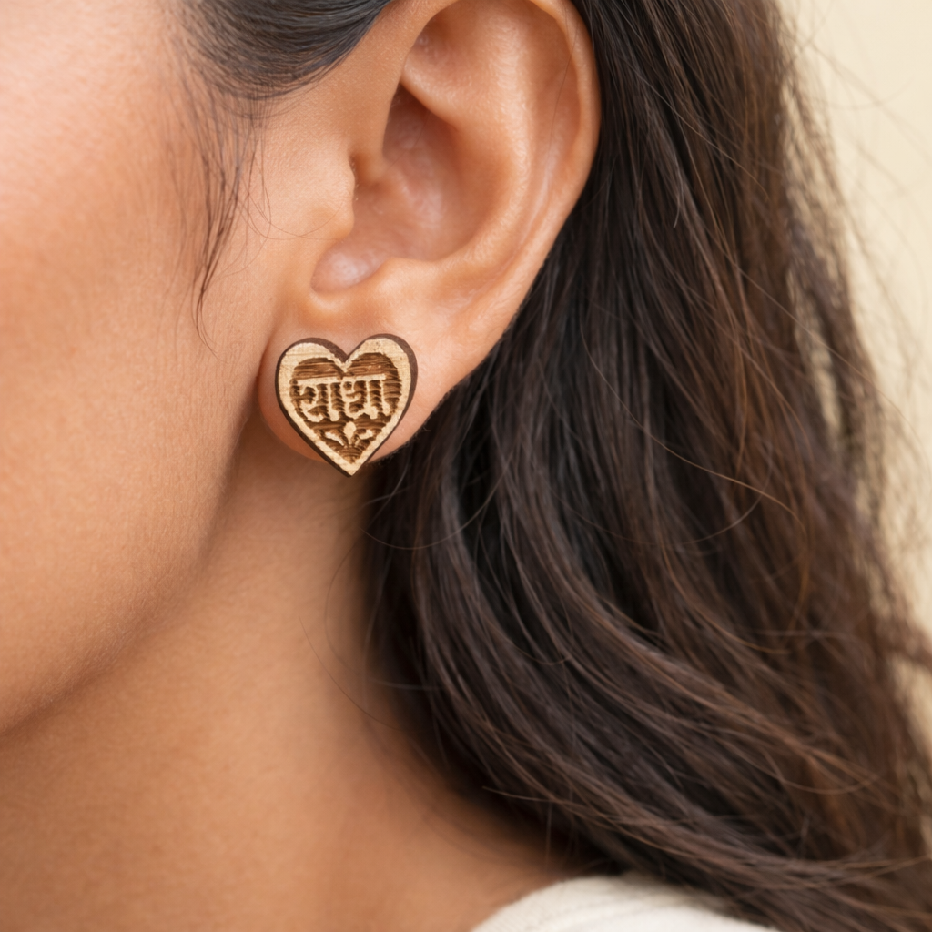 Heart-shaped earring worn by a person with brown hair.