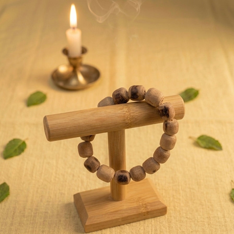 Handmade 8mm Tulsi beads bracelet displayed on wooden stand with warm devotional aesthetic.